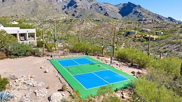 A basketball court with a mountainous backdrop, surrounded by cacti and sparse vegetation.
