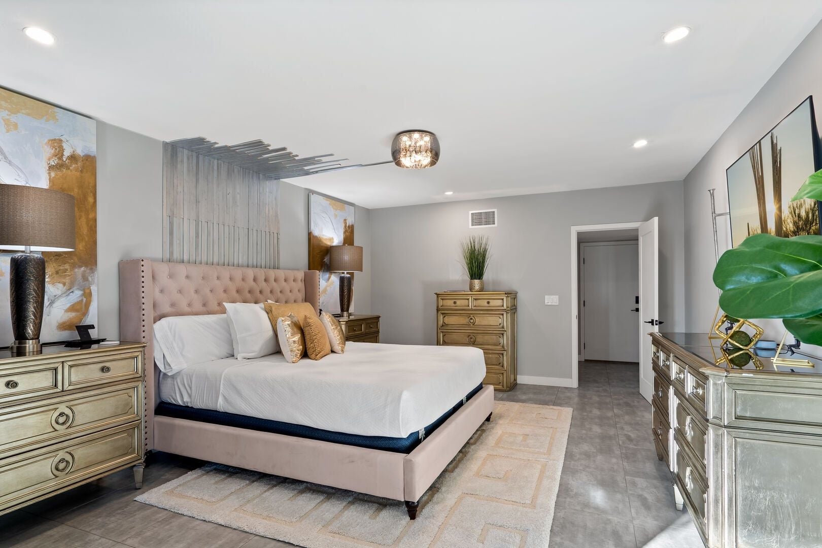 A bedroom with a bed, nightstands, a dresser, and a large painting on the wall.