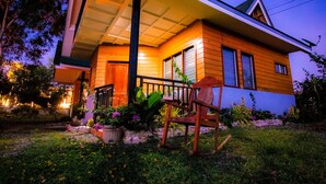 A two-story house with a porch, wooden siding, and a visible front door. - Ana-as Apartelle  (Panglao)