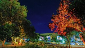 A nighttime view of a hotel with a well-lit garden and a clear night sky. - Ana-as Apartelle  (Panglao)