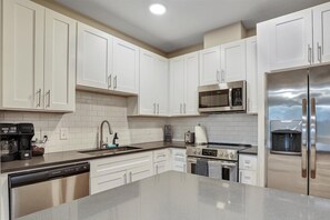 Enjoy cooking in this well-equipped kitchen with a microwave, gas stove, and stainless steel appliances.