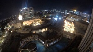 A nighttime view of a hotel with a central courtyard, multiple buildings, and a pool area. - VenizLex  (Taguig)