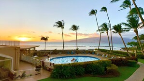 Ein Hotelpool mit Blick auf den Ozean und den Sonnenuntergang.