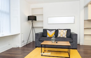 Relax in this stylish living room with a sofa, coffee table, and floor lamp.