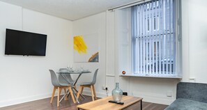Relax in this stylish living space with a flat-screen TV, dining area, and comfortable sofa.