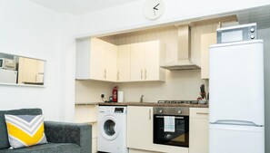 Kitchen features an oven, washing machine, and refrigerator.