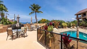 Un espace piscine sur le toit, doté d’une balustrade en verre, de coins salon extérieurs et offrant une vue sur l’océan.