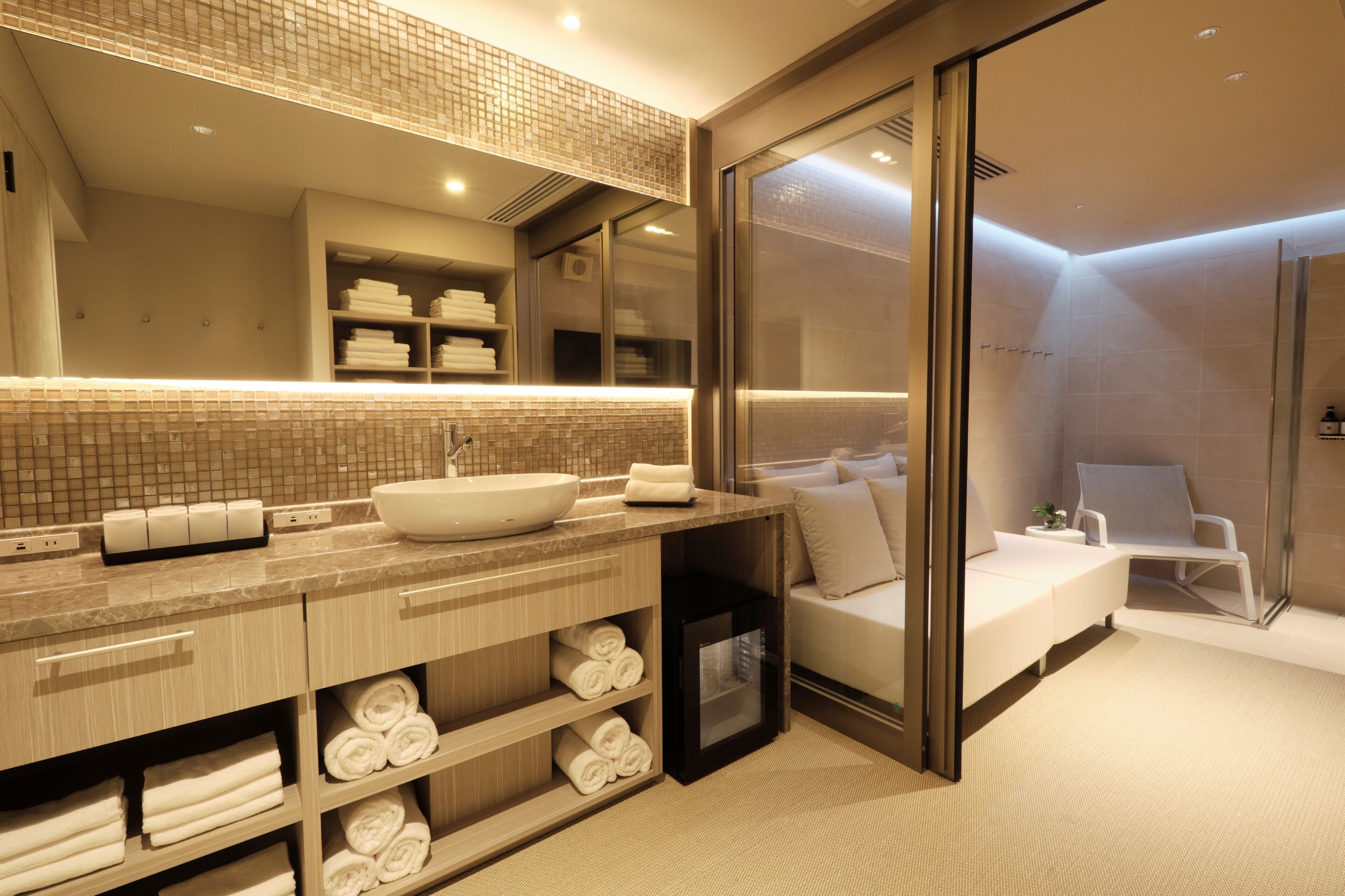 A modern bathroom with a large mirror, a sink, and a shower area.