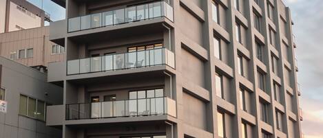 Un edificio moderno de varios pisos con balcones y ventanas amplias.