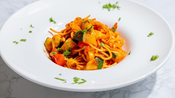 A white plate with a pasta dish garnished with herbs. - FAV LUX HIDATAKAYAMA (Takayama)