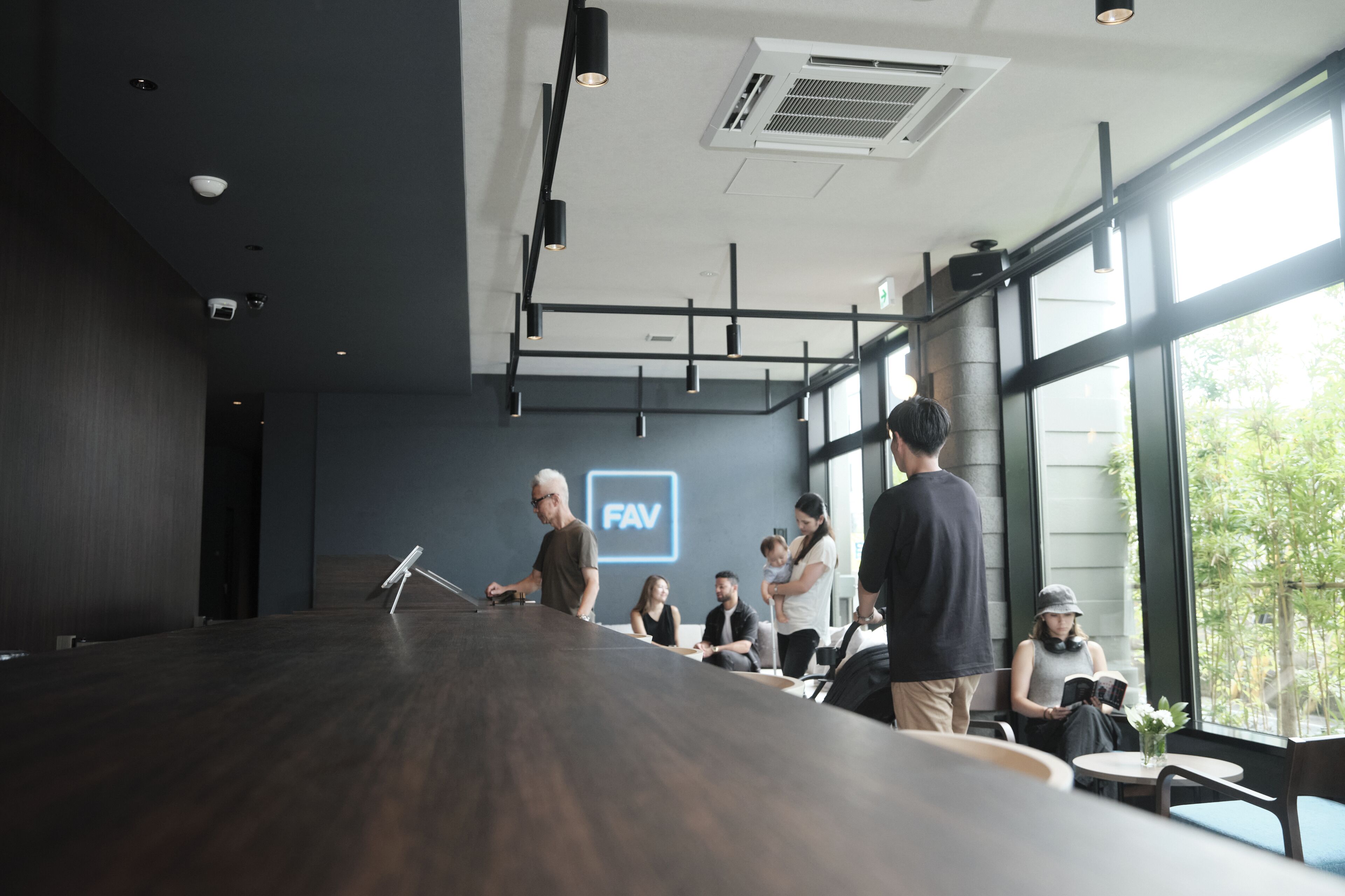 Ein moderner Konferenzraum mit einem langen Tisch, einem Projektor und einem großen Fenster mit Blick auf Grünflächen.