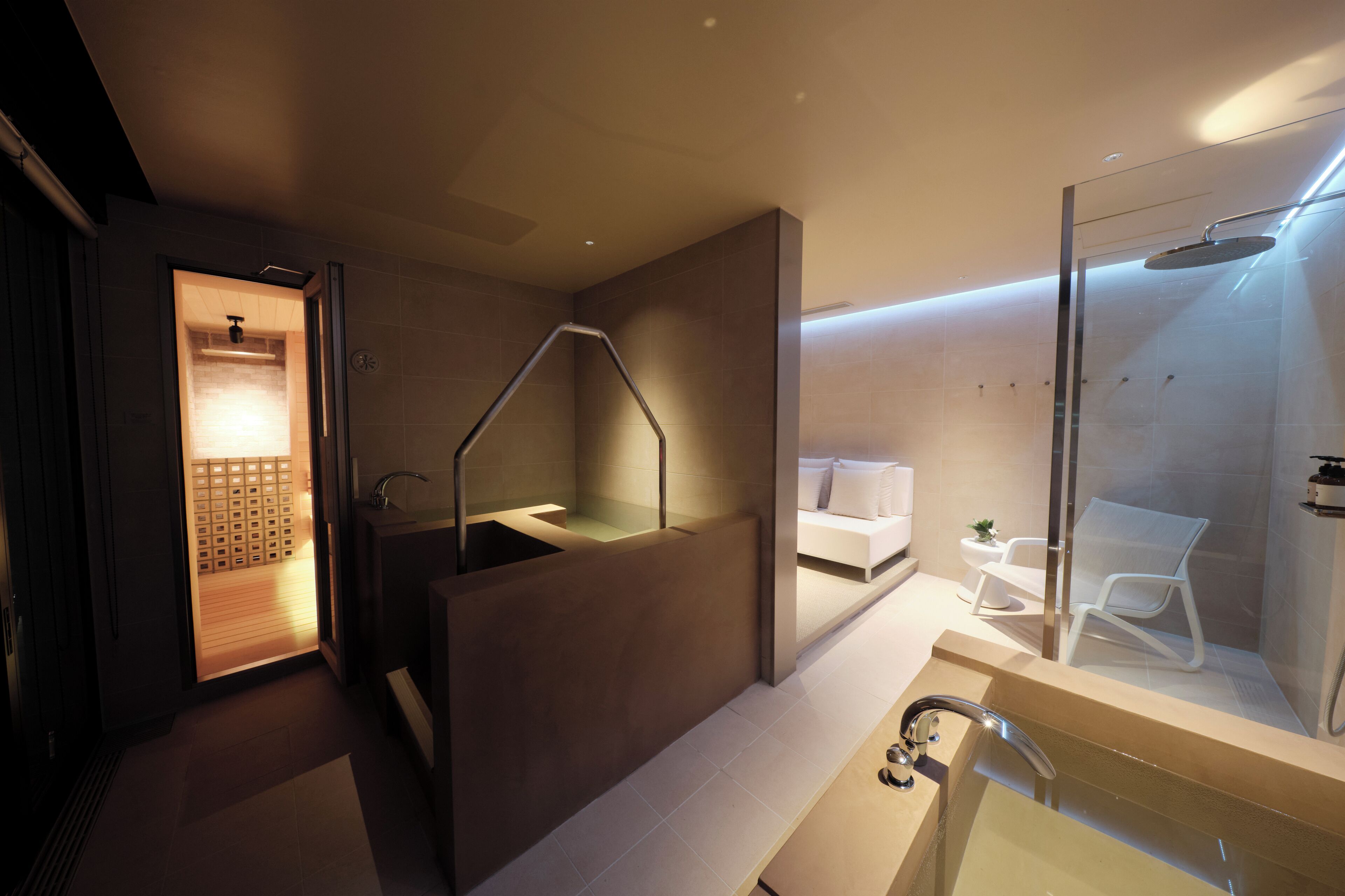 Een moderne badkamer met een douchecabine van glas, een afzonderlijk wastafelgedeelte en een zichtbare handdoekhouder.