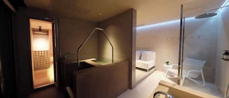 A modern bathroom with a glass-enclosed shower, a separate sink area, and a visible towel rack.