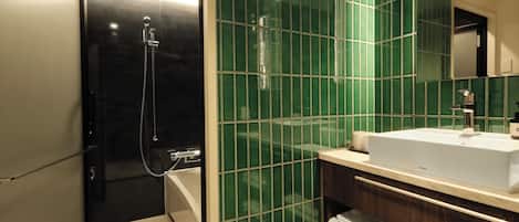 A modern bathroom with a shower, a sink, and a mirror.