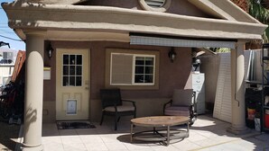 A house with a unique architectural design, featuring a circular window and a porch with a table and chairs. - close to downtown, to Strip Las Vegas , Arts District, (Las Vegas)