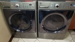 A pair of front-loading washing machines with control panels, placed on a tiled floor. - close to downtown, to Strip Las Vegas , Arts District, (Las Vegas)