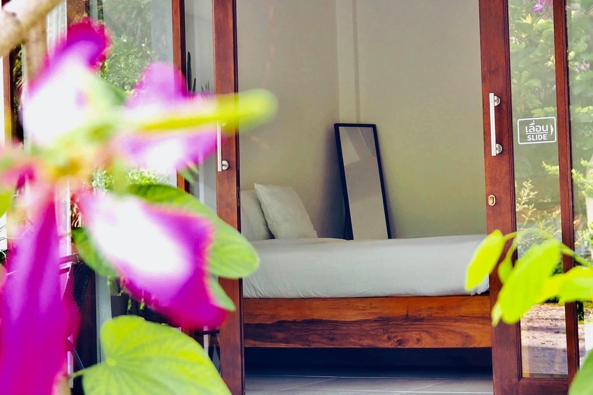 Una habitación con cama, espejo y puerta corrediza.