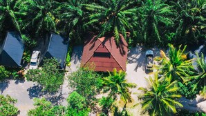 An aerial view of a resort with multiple buildings, palm trees, and a swimming pool. - Maliblue resort khanom (Khanom)