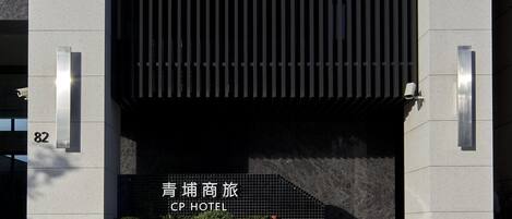 A modern hotel entrance with a large overhang and a sign indicating the name 'CP Hotel'.