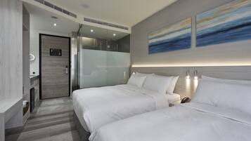A modern hotel room with two beds, a shower area, and artwork on the wall.