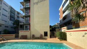 Un hotel con piscina, mobiliario exterior y vistas de los edificios circundantes.