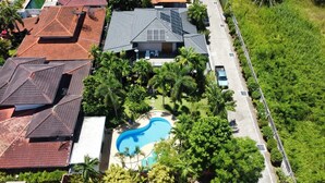 Vista aérea de una zona residencial con casas, piscina y zonas verdes.