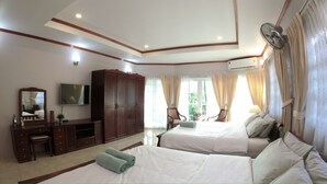 Una habitación de hotel con dos camas, televisión, armario y escritorio.