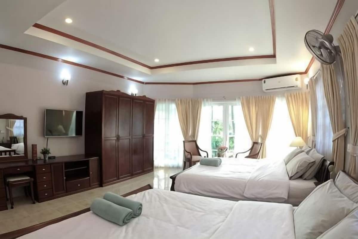 Une chambre d’hôtel avec deux lits, une télévision, une armoire et un bureau.