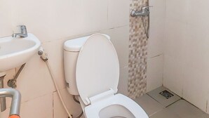 Une salle de bain équipée de toilettes, d’un lavabo et d’une douche.