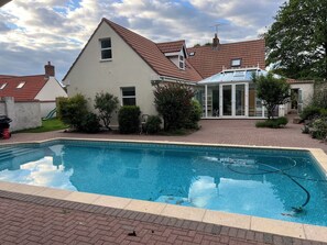 Una piscina al aire libre, una piscina climatizada