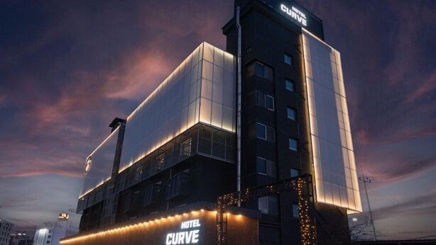 A modern hotel building with a prominent sign reading "HOTEL CURVE." - CURVE HOTEL IKSAN (Iksan)