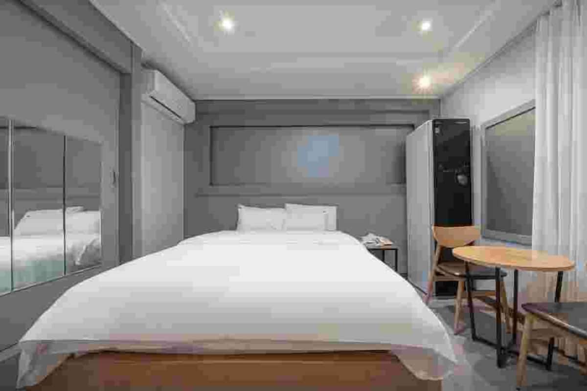 Ein modernes Hotelzimmer mit einem großen Bett, einem kleinen Tisch und einem Stuhl.