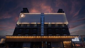 A hotel with a modern design, featuring a prominent 'Curve' sign, multiple floors, and a well-lit facade. - CURVE HOTEL IKSAN (Iksan)