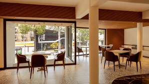 A modern interior with a large open space, wooden ceiling, and large windows offering a view of the street. - DAI NAM BOUTIQUE HOTEL (Ho Chi Minh City)