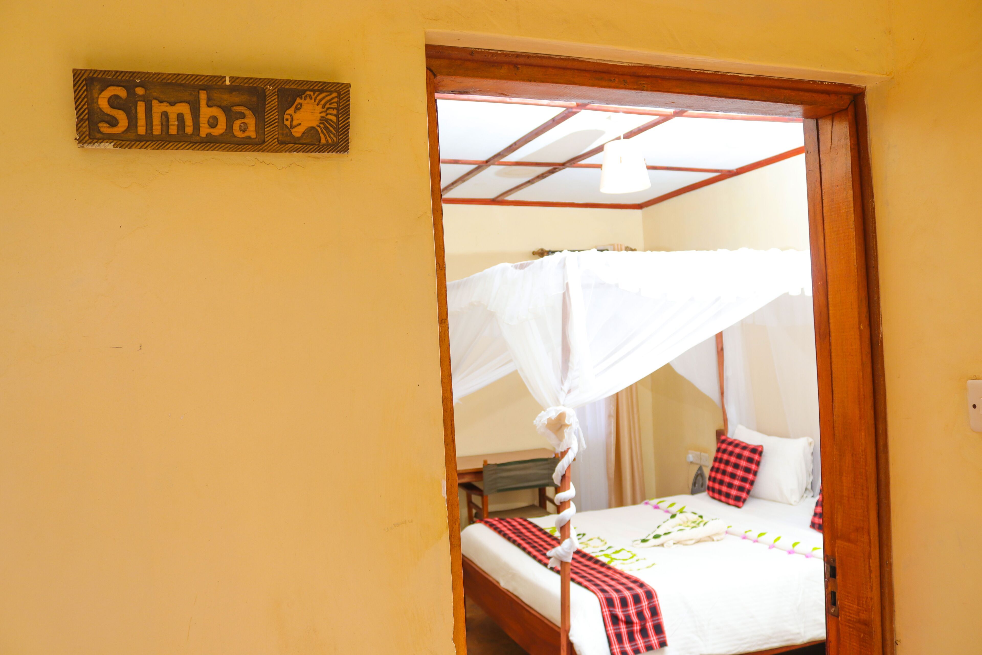 A room with a bed, a canopy, and a sign reading "Simba".