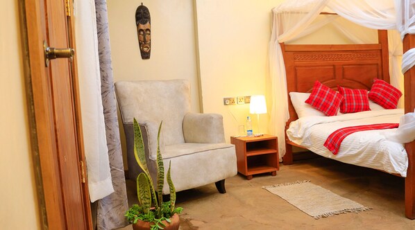 Une chambre à coucher avec un lit, une table de chevet, une chaise, une plante en pot et une porte.