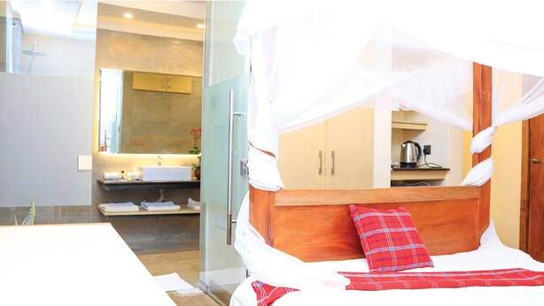 A hotel room with a bed, a bathroom, and a kitchenette. - River Lumi Resort - Taveta (Chala)