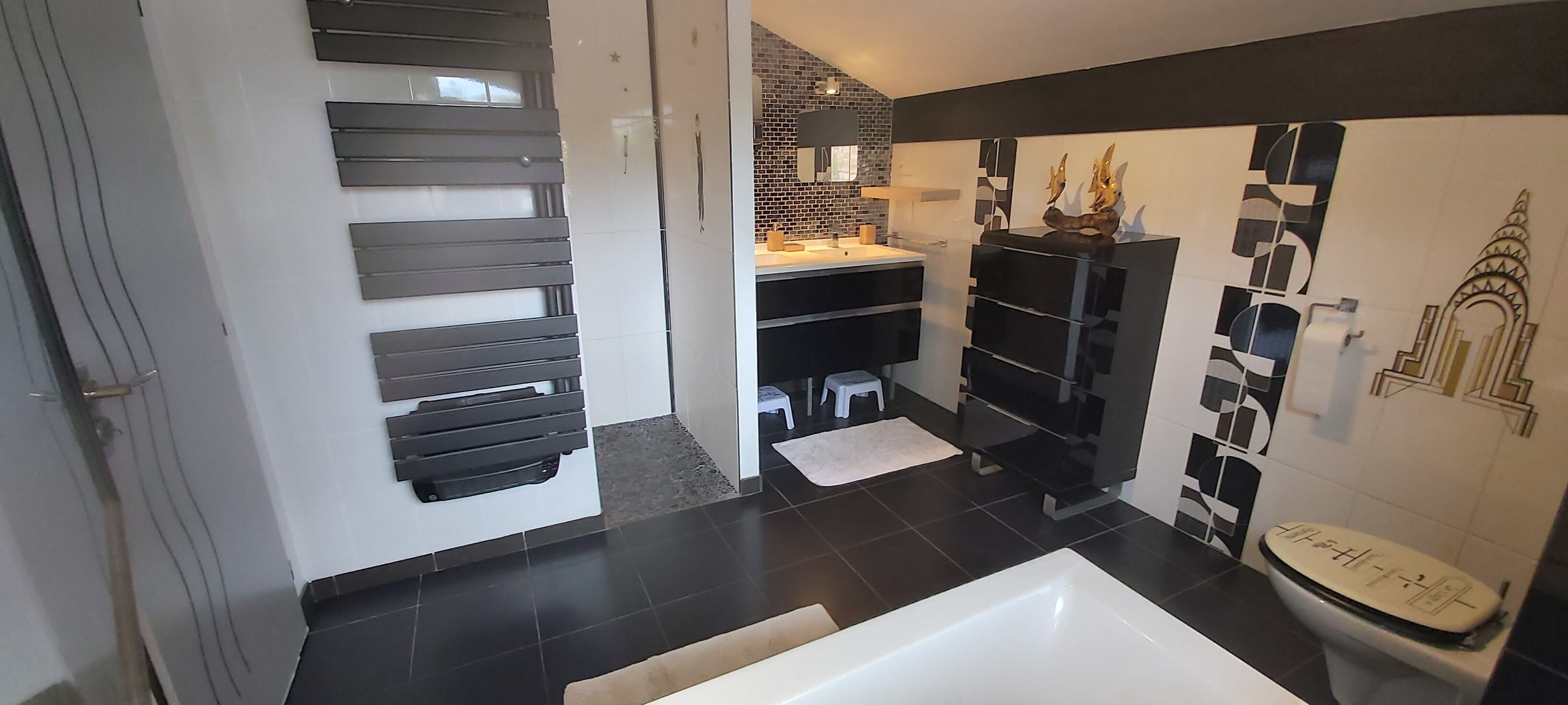 A modern bathroom with a bathtub, a toilet, and a sink.