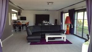 A modern living room with a black sofa, a white coffee table, and a purple rug. - LUXURY VILLA / SWIMMING POOL / SPA / 600m FROM THE BEACH / 12 GUESTS (Agde)