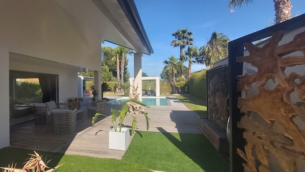A modern house with a patio, outdoor furniture, a swimming pool, and a stone wall. - LUXURY VILLA / SWIMMING POOL / SPA / 600m FROM THE BEACH / 12 GUESTS (Agde)