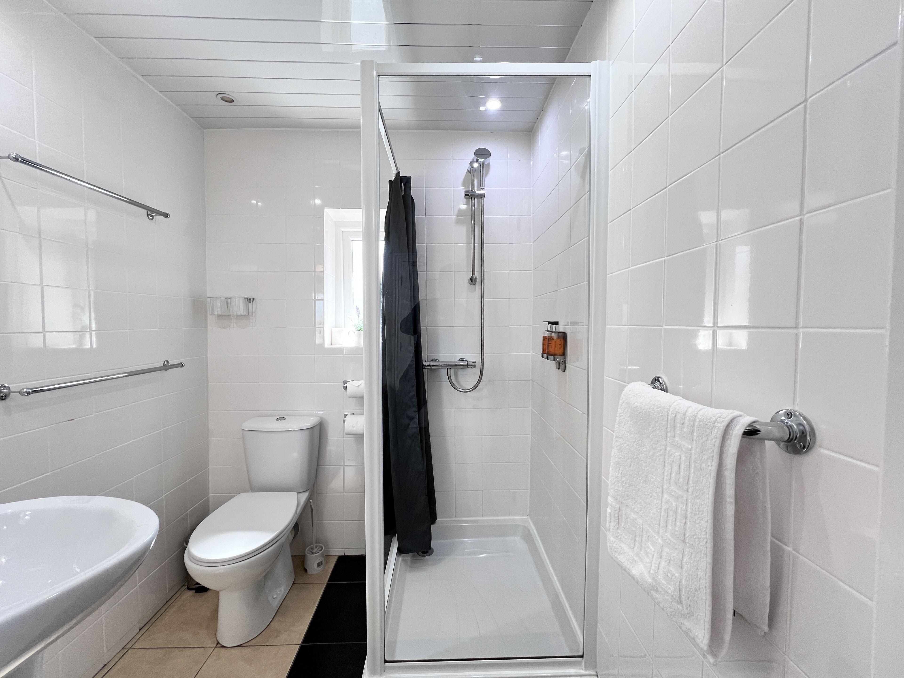 A modern bathroom with a shower, toilet, and bathtub.