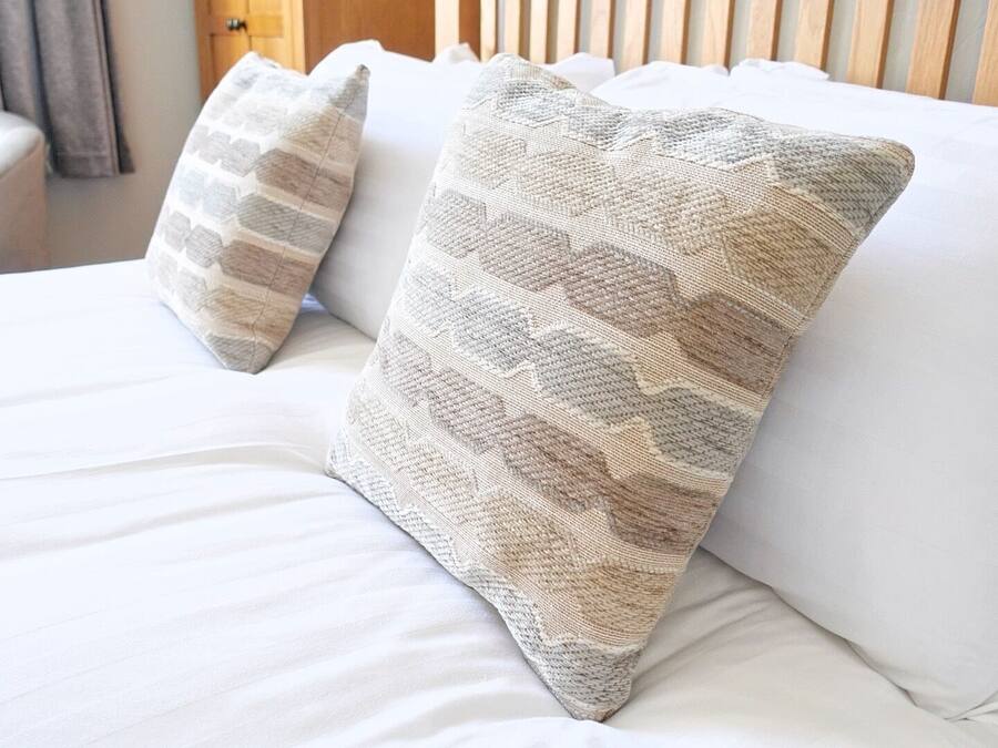 Two pillows on a bed with a wooden headboard.
