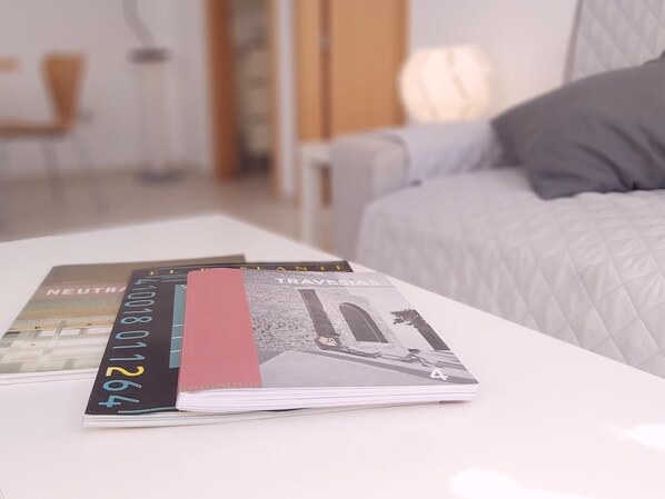 A neatly arranged stack of travel brochures on a white table in a hotel room.