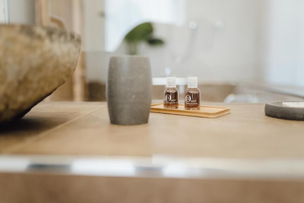 Een houten tafel met twee flesjes lotion en een klein dienblad.