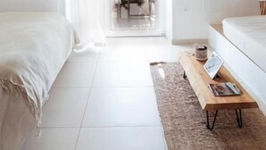 A bright, minimalist bedroom with a large window, a wooden coffee table, and a hanging light fixture. - Break For Two (Agropoli)