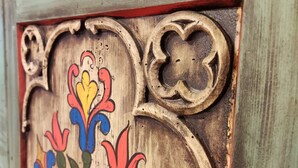 A wooden door with intricate carvings and a floral design. - Appartement am Weißbach - Urlaub im Pfrontener Tal (Pfronten)