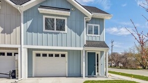 A two-story house with a garage, a front door, and a small porch. - My Glacier Getaway - 3 min to downtown Kalispell! (Kalispell)
