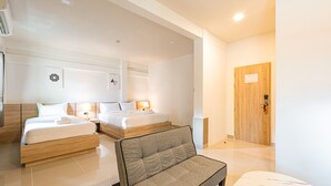 Una habitación de hotel con dos camas, un sofá y una puerta de madera.