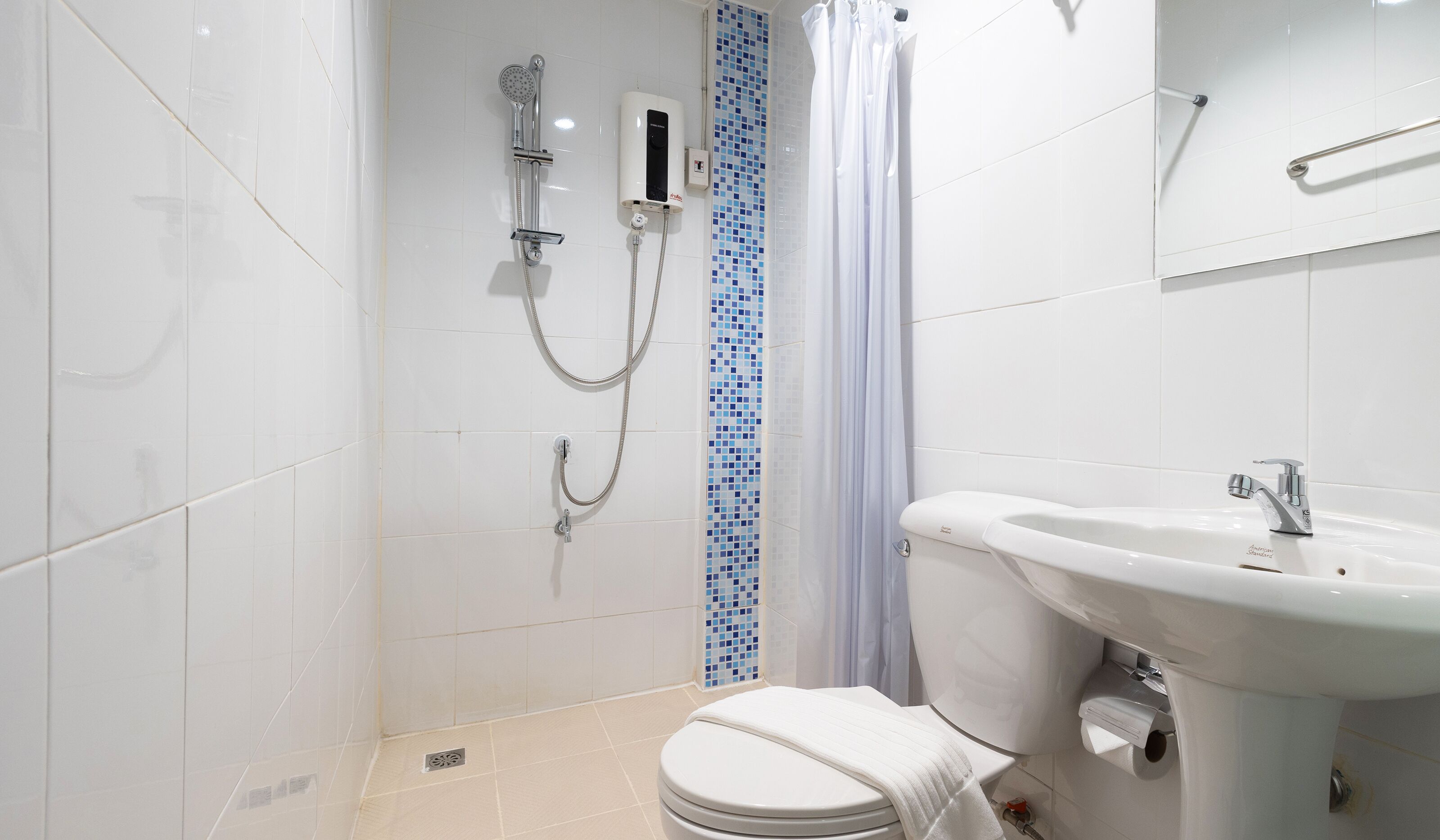 A modern bathroom with a toilet, a sink, and a shower.