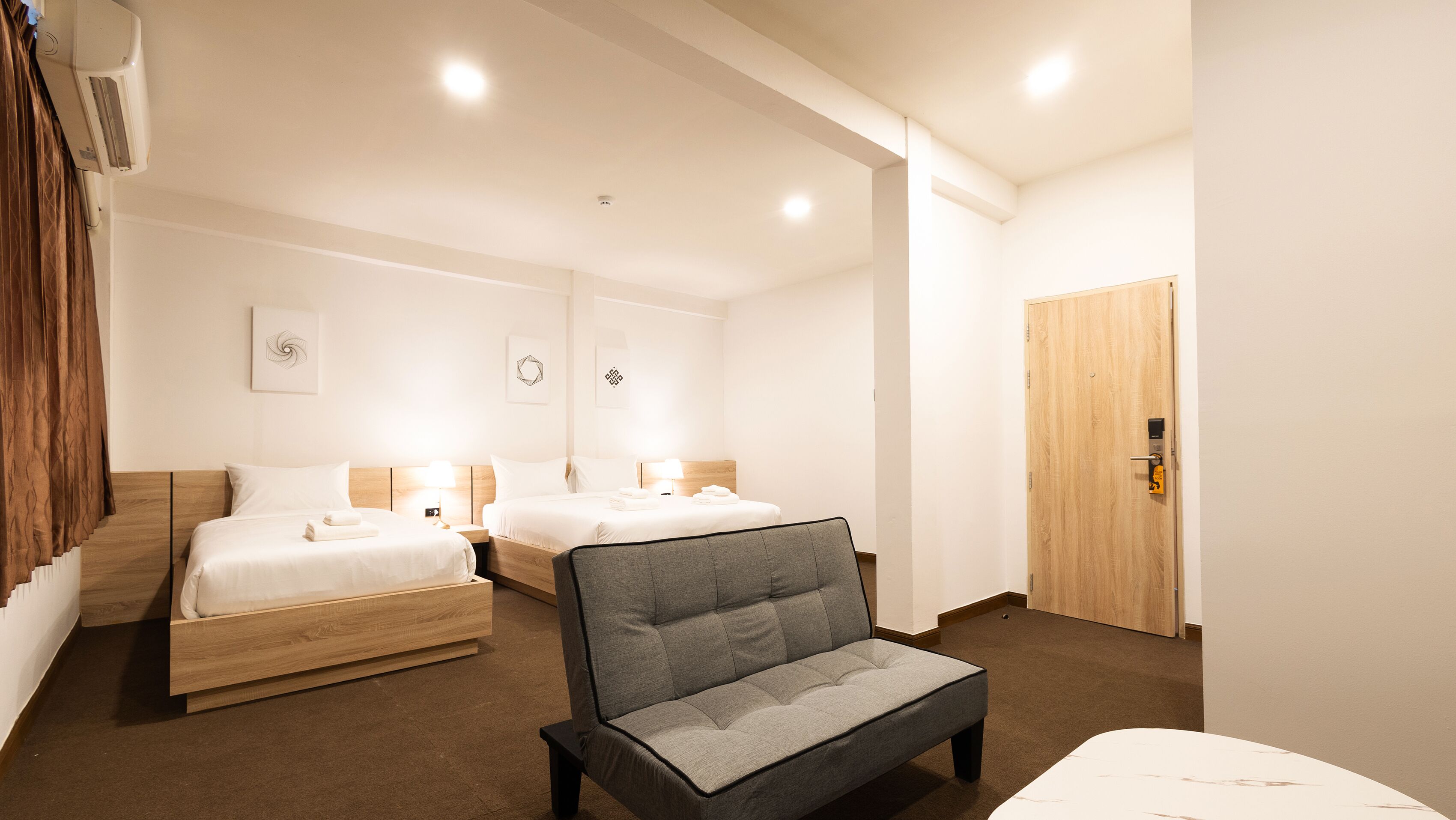 Una habitación de hotel con dos camas, un sofá, una puerta de madera y una escalera.